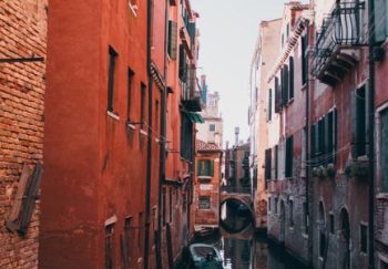 A picturesque view of a Venetian canal lined with gondolas and historic buildings in Venice, Italy.