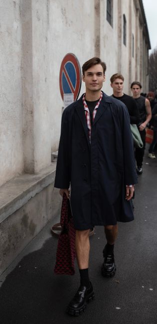 Group of fashionable men strolling on a street in Milano, showcasing casual yet trendy style.