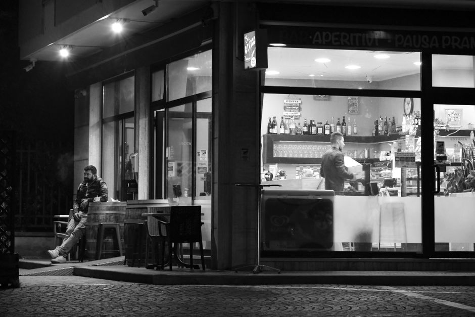 Elegant grayscale image of a coffee bar at night in Castel d'Azzano, Italy.