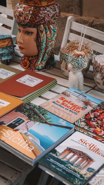 Vibrant display of Sicilian ceramics and literature in Sirakusa, Italy.