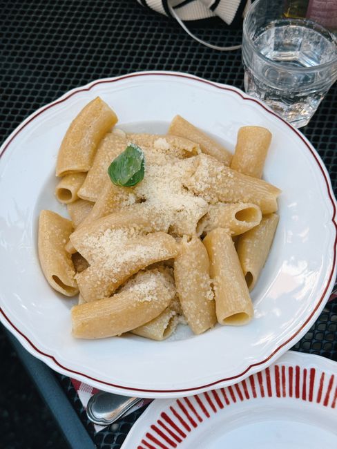 Authentic rigatoni pasta with parmesan, captured outdoors in Milan, Italy.