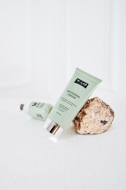 Minimalist display of skincare products with a natural stone, emphasizing elegance and simplicity.