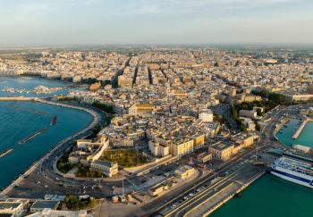 A breathtaking drone capture of a coastal city with a bustling harbor, showcasing beautiful architecture and sea.