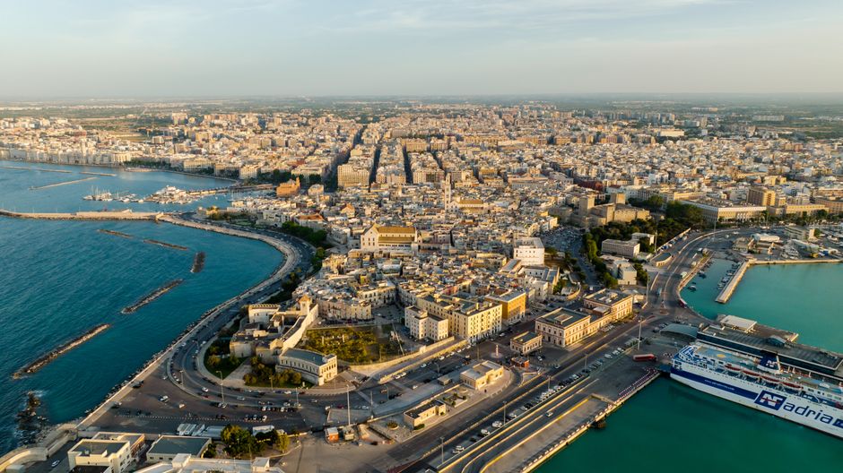 A breathtaking drone capture of a coastal city with a bustling harbor, showcasing beautiful architecture and sea.