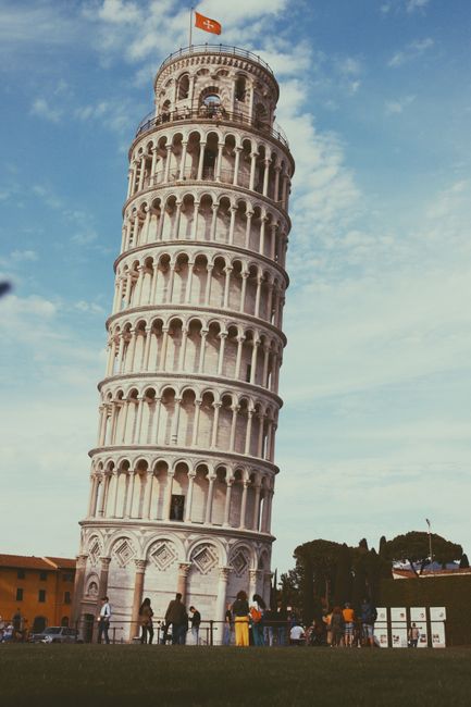 The famous Leaning Tower of Pisa with tourists in a sunny day in Tuscany, Italy.