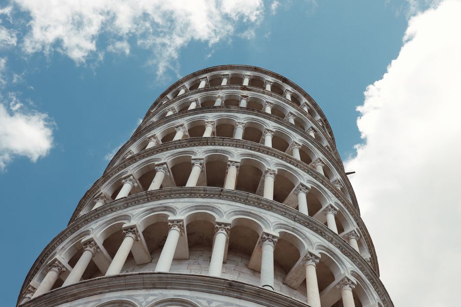 Close-up of the iconic Leaning Tower of Pisa with beautiful arches and a clear blue sky.