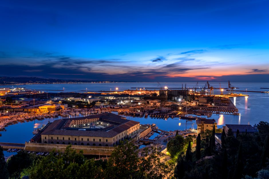 A breathtaking aerial view of Ancona port at sunset, showcasing vivid colors and industrial docks.