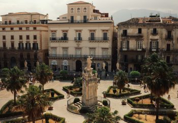 Aerial shot of a historic piazza in Palermo, Italy with landmarks and urban architecture.