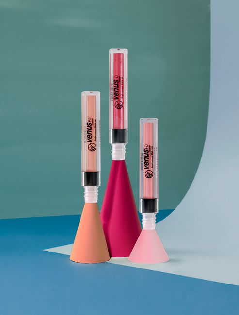 Stylish lip gloss tubes displayed on modern geometric shapes, perfect for beauty and fashion themes.