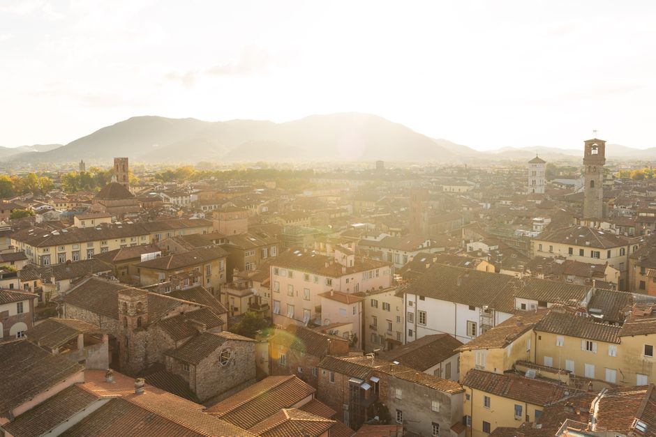 A picturesque aerial view of Lucca's historic rooftops at sunset, showcasing its architectural beauty.