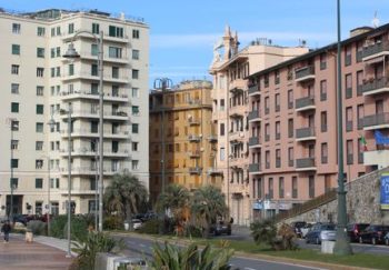 Street view of colorful buildings in Genoa, Italy on a clear winter day.