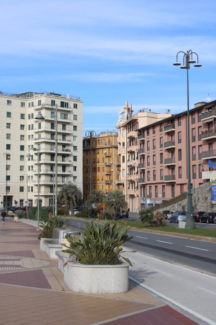 Street view of colorful buildings in Genoa, Italy on a clear winter day.