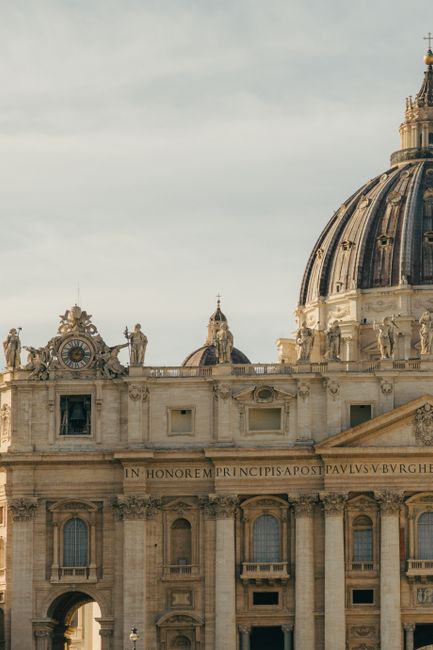 Close-up of St. Peter's Basilica facade in Vatican City under sunlight, showcasing architectural details.