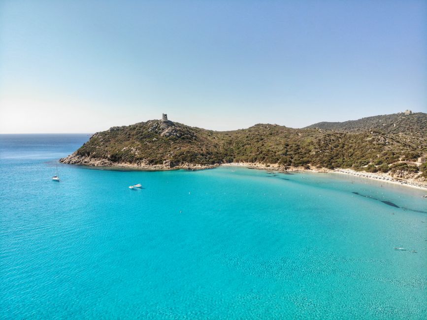A scenic aerial view of the Porto Giunco Tower and turquoise waters in Villasimius, Sardinia, Italy.