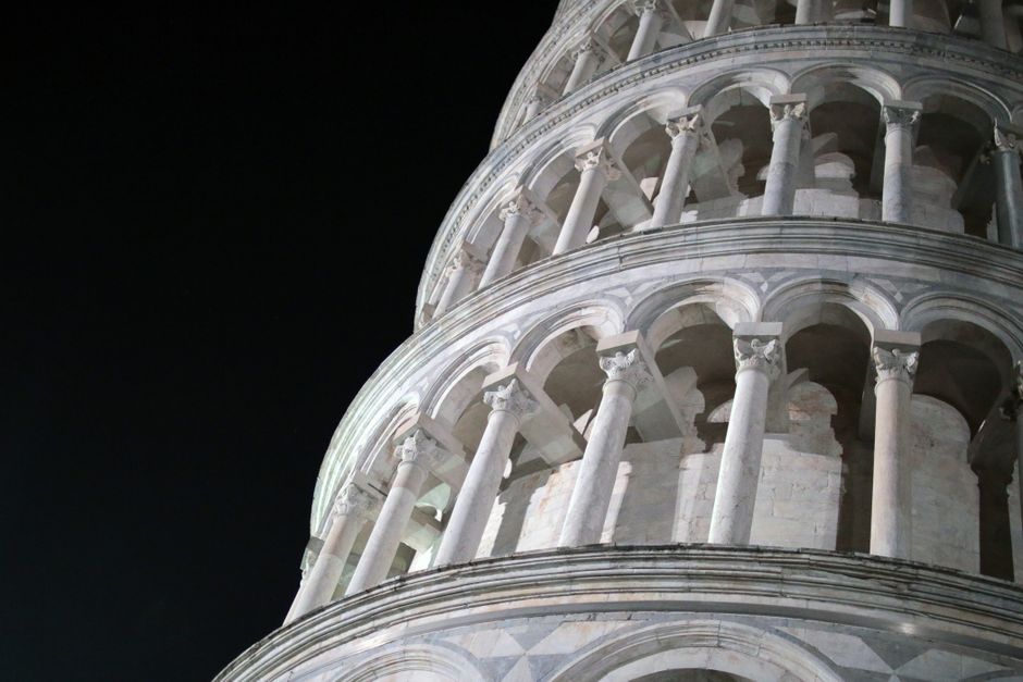 Captivating close-up of the Leaning Tower of Pisa illuminated against a night sky.