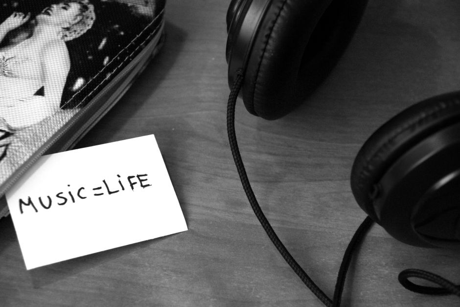 Close-up of headphones and a note saying 'Music = Life', perfect for music lovers and backgrounds.