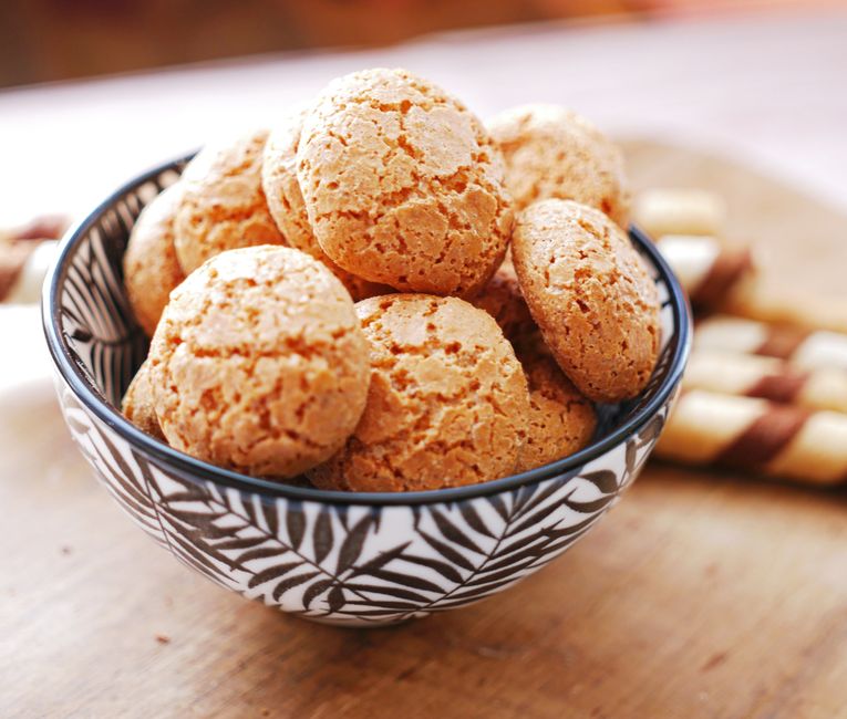 Close-up of almond cookies in a patterned bowl, perfect for dessert displays.