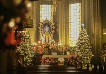 A beautifully decorated church interior featuring stained glass windows and festive decorations.