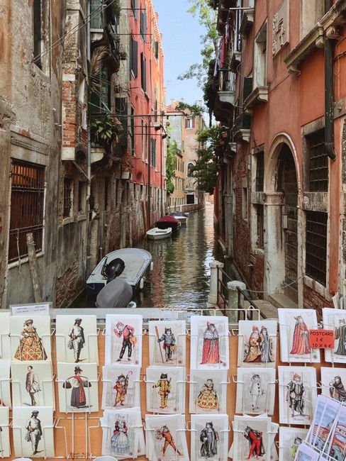 Charming canal view in Venice featuring historic postcards and colorful buildings.