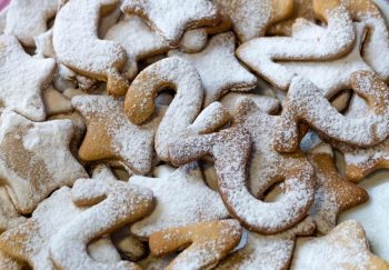Close-up of star and number shaped cookies dusted with powdered sugar, perfect for holiday baking.