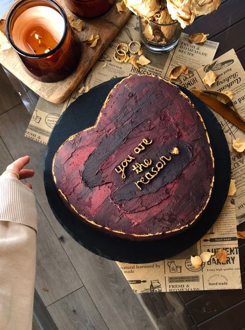 A heart-shaped cake with 'you are the reason' on a tray, perfect for celebrations.