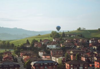 Charming landscape of Barolo, Italy with hot air balloon over rolling hills.
