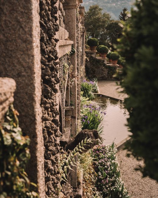 Explore the picturesque villa garden in Stresa, Italy, featuring stone walls and lush greenery.