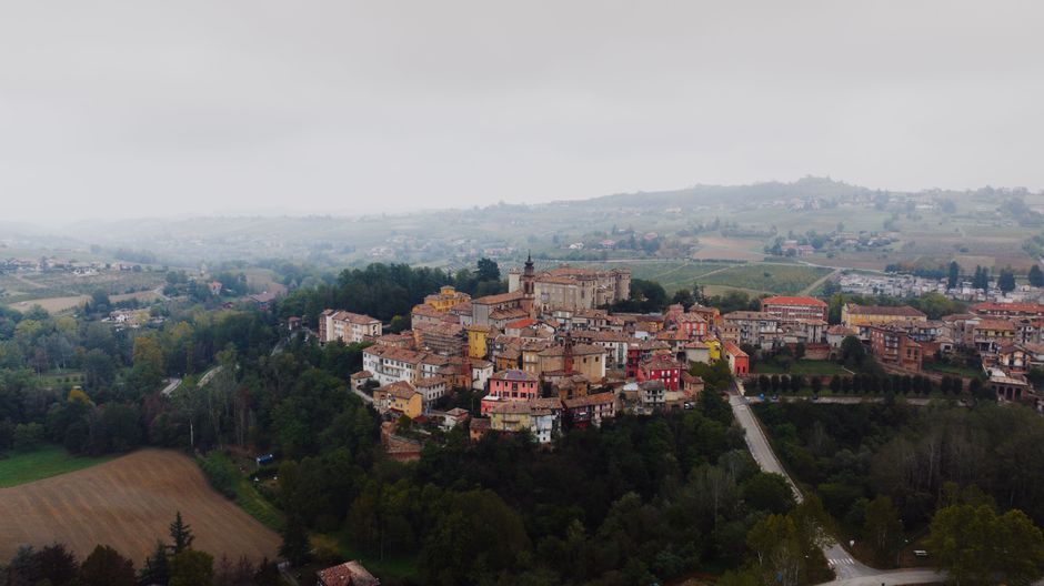 Scenic aerial view of Costigliole d'Asti village amidst lush countryside in Piemonte, Italy.