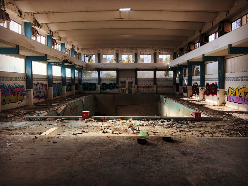 Explore this eerie, abandoned indoor pool in Foggia, Italy, filled with graffiti and debris.
