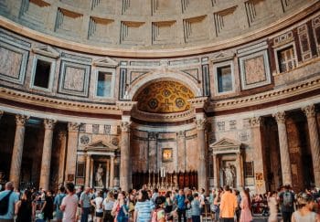 Interior view of the Pantheon in Rome filled with tourists capturing the grandeur of ancient architecture.
