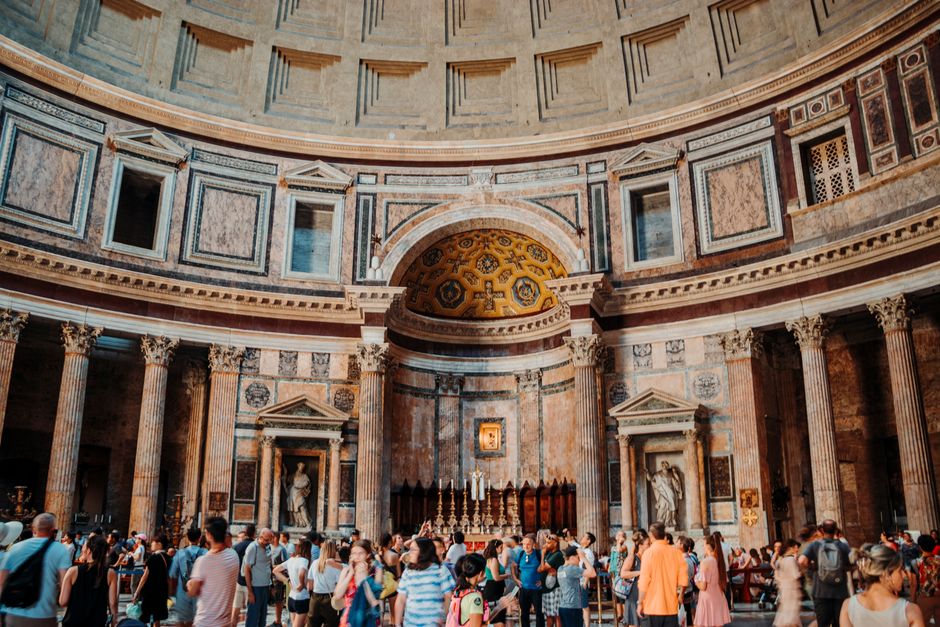Interior view of the Pantheon in Rome filled with tourists capturing the grandeur of ancient architecture.