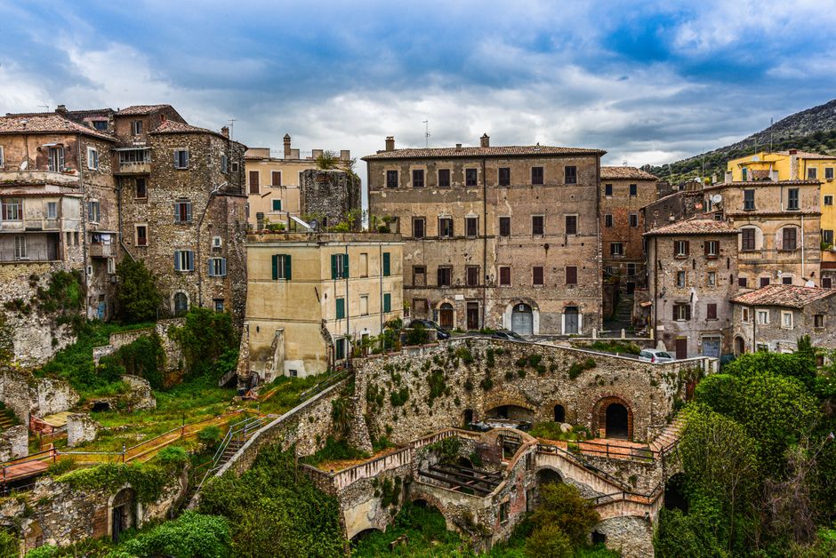 Charming historic buildings in Tivoli, Italy under a cloudy sky.