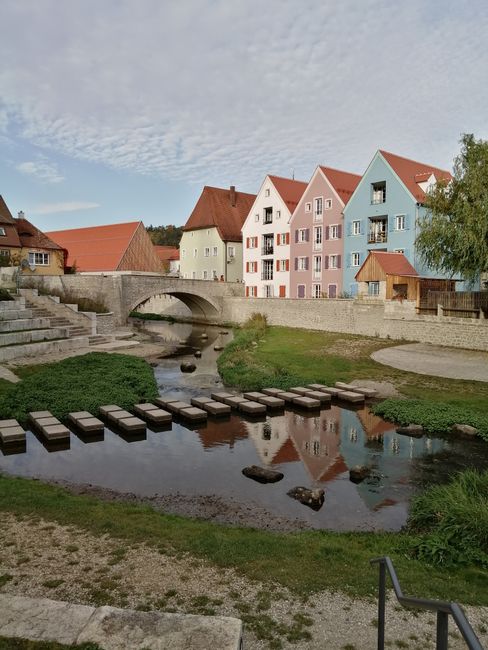 Picturesque view of colorful houses and a stone bridge reflected in river, Europe