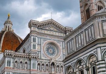 Stunning view of Florence Cathedral's intricate facade and bell tower under dramatic skies.