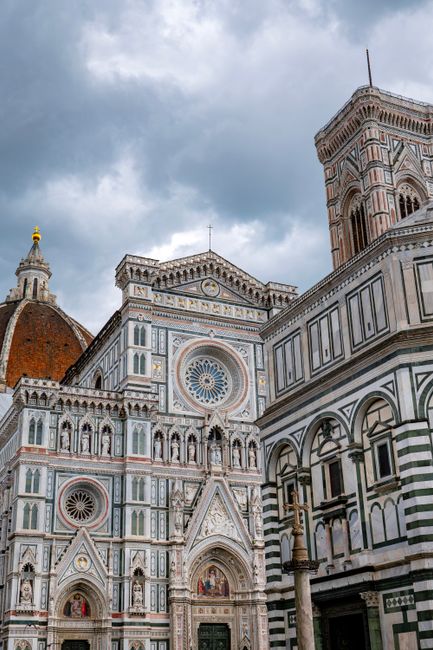 Stunning view of Florence Cathedral's intricate facade and bell tower under dramatic skies.