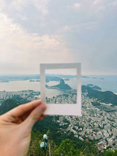 Hand holding square frame with view of Sugarloaf Mountain, Rio de Janeiro.
