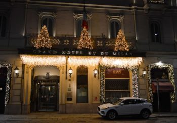 Night view of Grand Hotel et de Milan adorned with festive Christmas lights, capturing holiday elegance.
