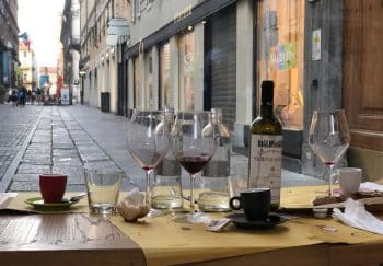 Empty wine glasses on a street-side table in Turin, Italy, create a charming urban ambiance.