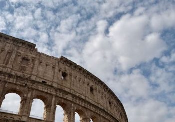 Capture of Rome's Colosseum with dramatic clouds highlighting ancient architecture.