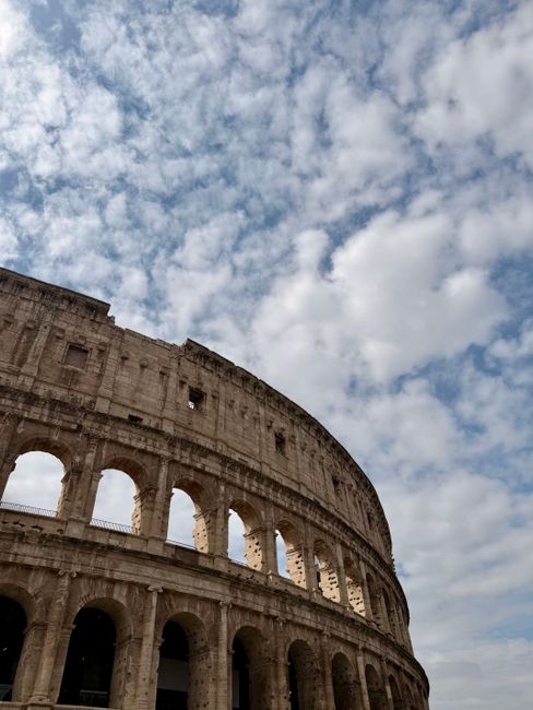 Capture of Rome's Colosseum with dramatic clouds highlighting ancient architecture.