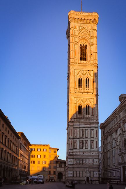 Stunning view of Giotto's Campanile bathed in sunset light in Florence's cityscape.