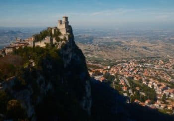 Discover San Marino's historic fortress perched dramatically atop Mount Titano overlooking the scenic landscape.