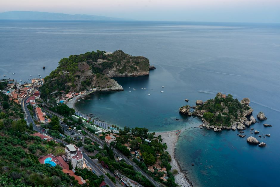 Breathtaking aerial shot of Isola Bella, Sicily, with lush green landscape and azure waters.