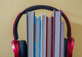 Creative setup of books with headphones symbolizing audiobooks and learning.
