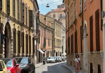 Charming street scene in Mantova, Italy with colorful historical buildings and a sunny atmosphere.