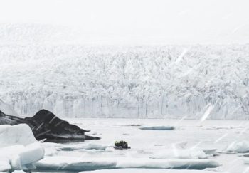 Picturesque view of frozen lake and forest covered with snow in beautiful winter day