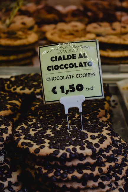 Close-up of chocolate cookies for sale in an Italian bakery with price tag.