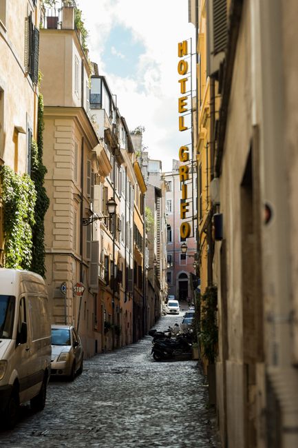 Explore the historic charm of a narrow cobblestone street in Rome, Italy, adorned with classic architecture.