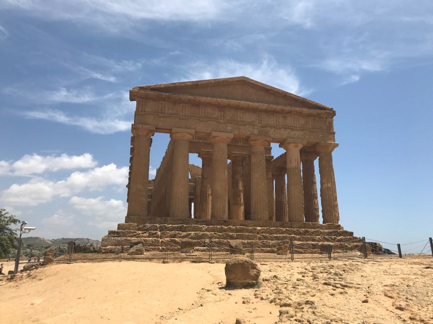 Historic Greek temple ruins under blue sky in Sicily's Valley of the Temples.
