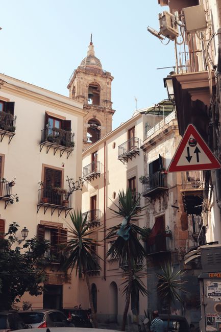 Charming street in Palermo, Sicily showcasing historical architecture and vibrant urban life.